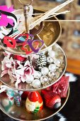 Various decorations and Christmas baubles on silver cake stand