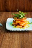 Pancetta chips with honeydew melon, rocket and an orange dressing