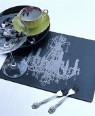 Table mat printed with chandelier motif, china cup and Champagne saucer