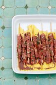 Raw lamb skewers in a marinade