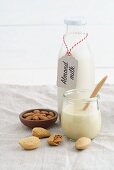 A jar of almond mousse and almond milk in a glass bottle