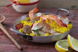 Oven-baked risotto with fish, chicken and garlic sausage