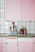 Kitchen counter with pink cabinets and concrete worksurface