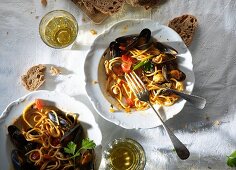Spaghetti with mussels, white wine and bread (seen from above)