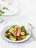 Salad Niçoise with fried tuna fish and soft-boiled eggs