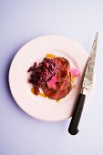 Marinated venison thick flank with a spicy crust served with a cranberry and red cabbage salad