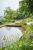 Idyllischer Teich mit Holzsteg in Gartenanlage