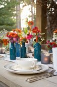 Gedeckter Tisch mit Suppentasse und Herbstblumen