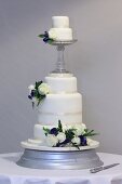 A white, multi-tiered wedding cake decorated with roses
