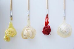 Various types of ice cream with brushes on a white surface