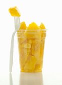 Pieces in pineapple in a plastic cup with a fork