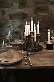 Weihnachten im Weinkeller: Gedeck auf rustikalem Holztisch mit Wein und Kerzen