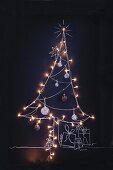 A Christmas tree drawn in chalk on a blackboard with fairy lights and baubles
