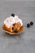 A cupcake with blackberries and blackberry cream