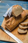 Sourdough bread sliced on a chopping board with a knife