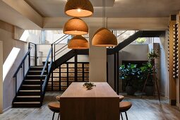 Vintner with wooden counter, bar stools, cork lampshades and steel staircase