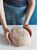 Spelt wholemeal bread being made: dough being shaped into a loaf