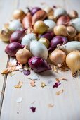 Various different coloured onions on a wooden table