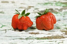 Two strawberries on a wooden table