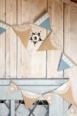 Hand-made bunting with lace trim on wooden façade of garden shed