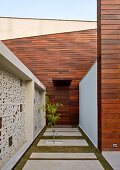 Courtyard of contemporary, Indian house with wood-clad façade and traditional Jali (perforated stone screen)