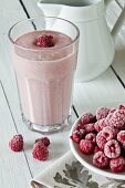 A raspberry smoothie and frozen raspberries