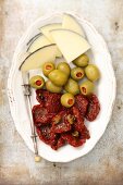 A tapas plater with cheese, olives and dried tomatoes