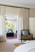 Antique armchair in bedroom in front of curtain, view of seat in loggia