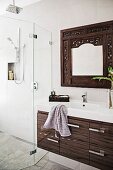 Vanity unit with modern drawer base cabinet, wall mirror with carved frame and glazed, floor-level shower area
