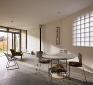 Open-plan living area with wood-burning stove, grey stone floor and minimalist furnishings