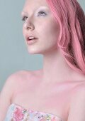 A woman with pink hair wearing a strapless top