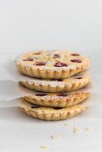 A stack of raspberry tartlets with icing sugar