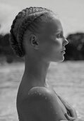 Junge Frau mit kunstvoller Flechtfrisur im Wasser (s/w-Foto)