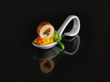 Saffron risotto and pork roulade on a serving spoon