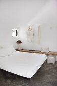 Simple double bed in minimalist bedroom with polished concrete floor