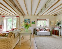 Rustic living room with wood-beamed ceiling, upholstered furniture and elegant ambiance