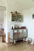 Upcycled sideboard in corner below collection of lighters in wall-mounted cabinet