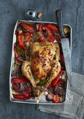 Stuffed roast chicken on a pepper and onion medley