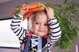 A little girl with fresh carrots