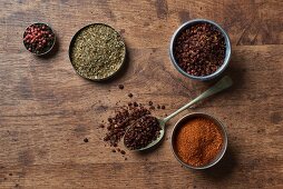 Various spices on a wooden surface (seen from above)