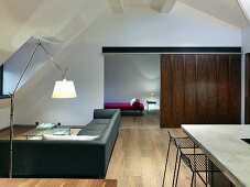 Offener Wohnraum mit Edelholz-Schiebeelement in minimalistischem Designerstil