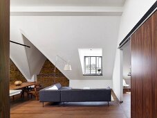Renovierte Dachgeschosswohnung mit Ziegelwand und Designermöbeln