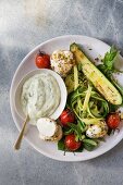 Warm courgette salad with mozzarella and tomatoes served with a yoghurt and basil sauce