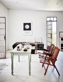 Animal skull on vintage dining table and wooden folding chairs in simple holiday home