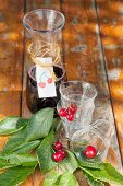 Carafe with hand-made label and glasses decorated with cherries
