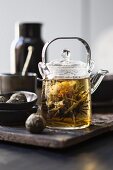 White tea in a glass teapot with a tea flower