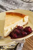 A cheesecake with white chocolate and berry sauce