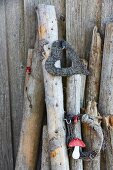 Heart-shaped wreaths and round twig wreath decorated with toadstool ornament hanging on logs leaning against wall