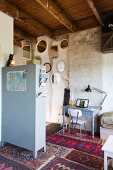 Desk and various Persian rugs in vintage-style room