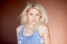 A blonde woman wearing a denim blue batik top